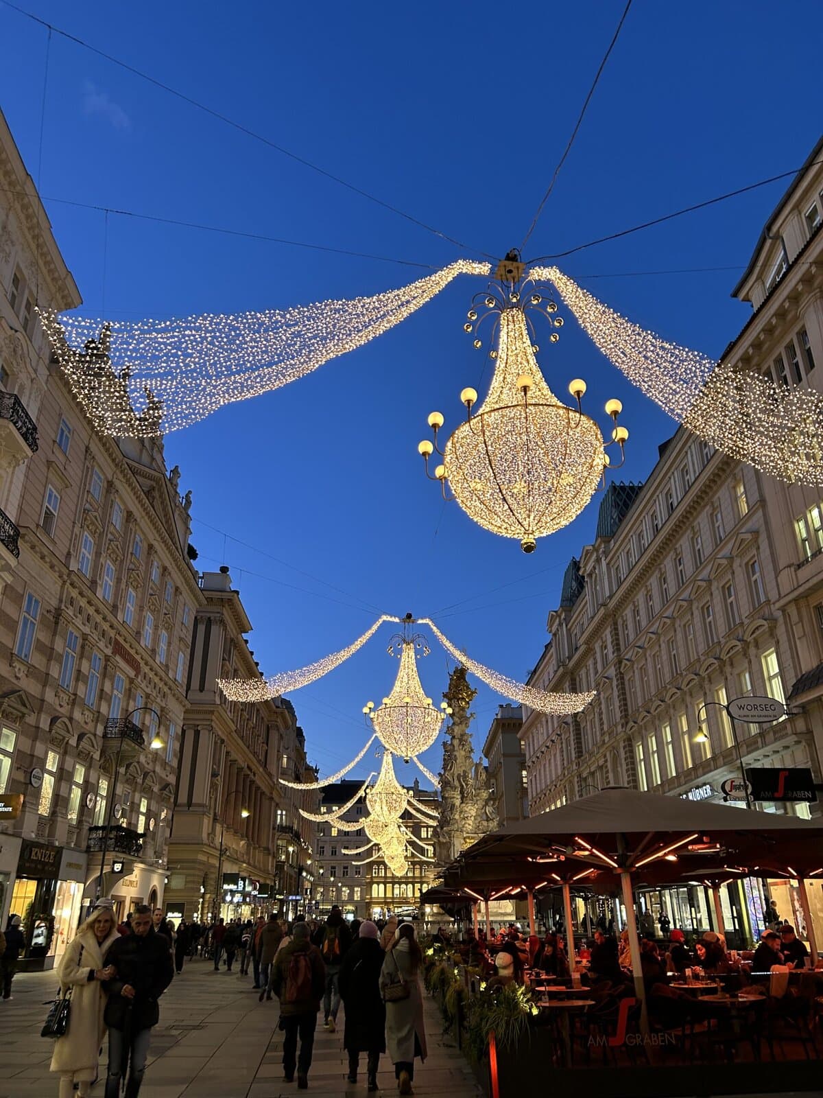A festive street in Vienna, Austria, illuminated by hanging Christmas lights at dusk. Just one of the many cities you may visit on a Christmas market river cruise 2025.