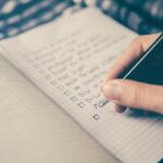 Traveler writing list of must do's before her river cruise inclusing buying travel insurance.