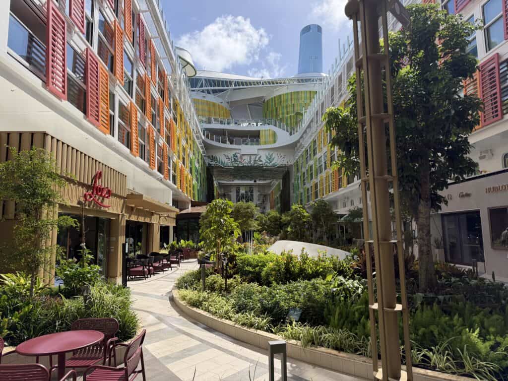Central Park neighborhood on Royal Caribbean Star of the Seas with restaurants, trees, and outdoor seating